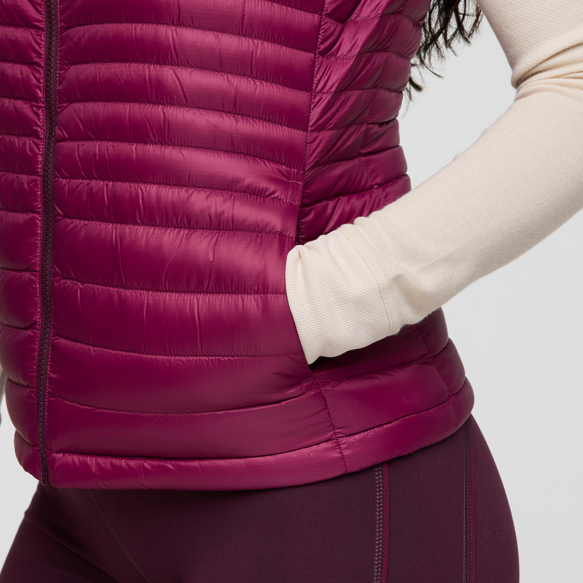 Close-up of magenta Cotopaxi Fuego Down Vest showing quilted panels and front zipper