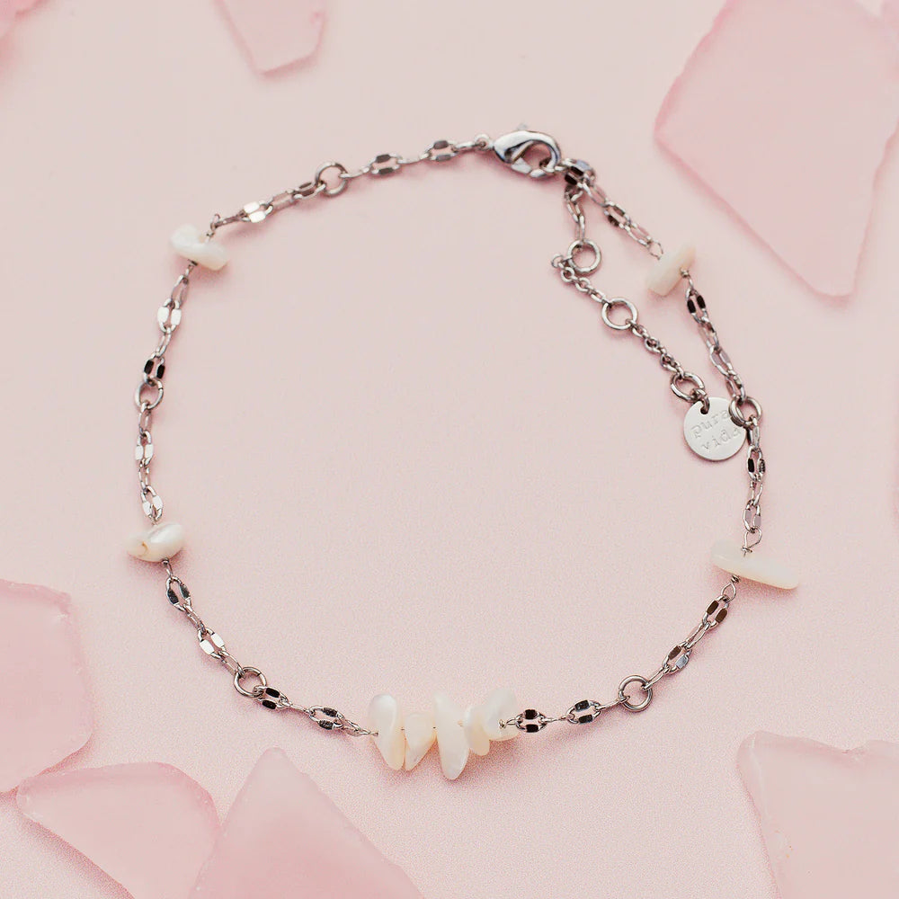 Sea Treasures Anklet with a delicate silver chain and small white shell charms on a pale pink background.