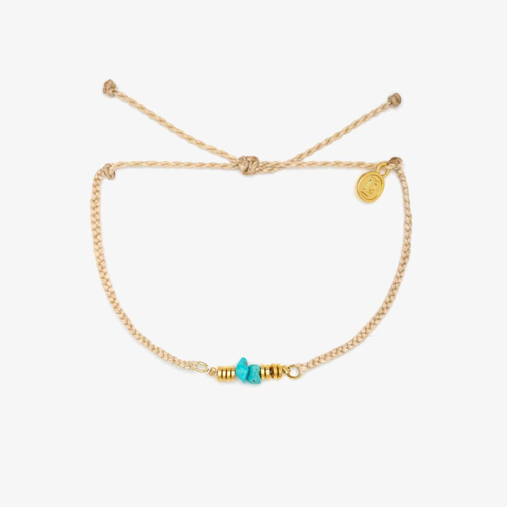 Beige braided anklet with turquoise chips and gold spacers laid flat on a white background.