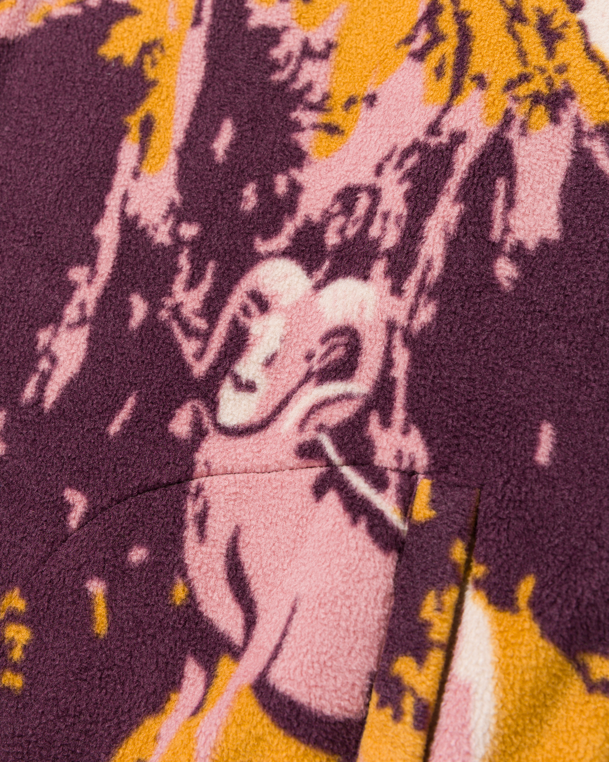 Close up of a vibrant purple pink and yellow printed fleece fabric pattern