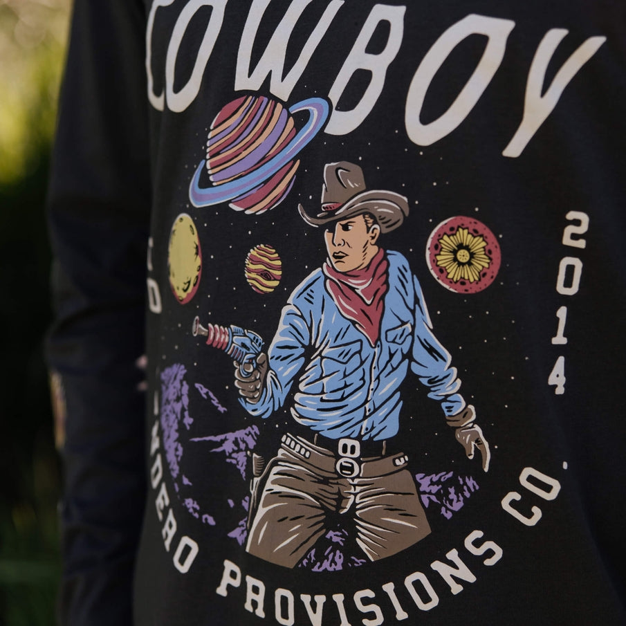 Close up of the Cosmic Cowboy graphic on black fabric showing the cowboy and planets.
