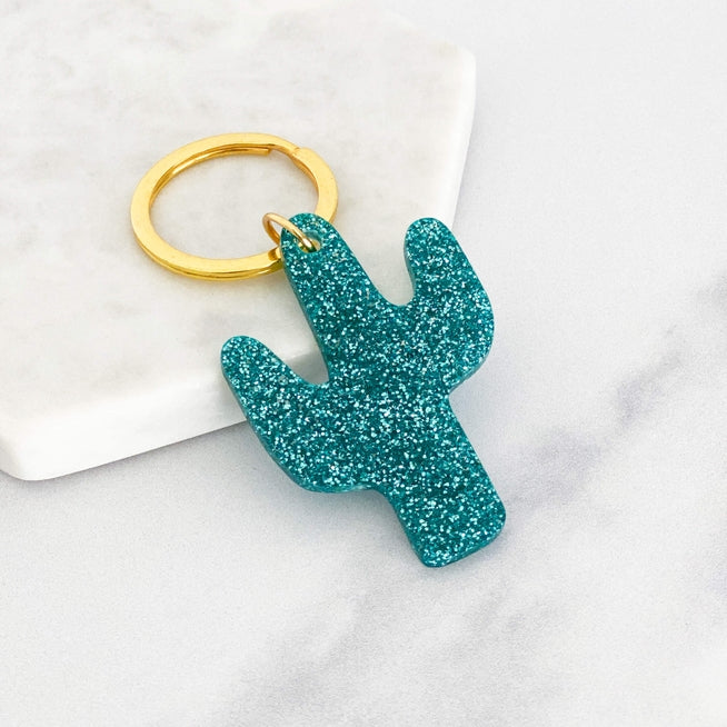 Acrylic cactus shaped keyring with teal glitter and a gold ring