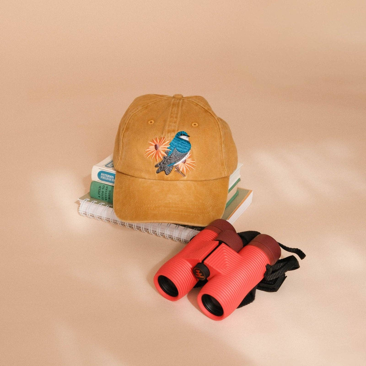 Embroidered small bird perched on a branch with blue flowers on a purple washed dad hat