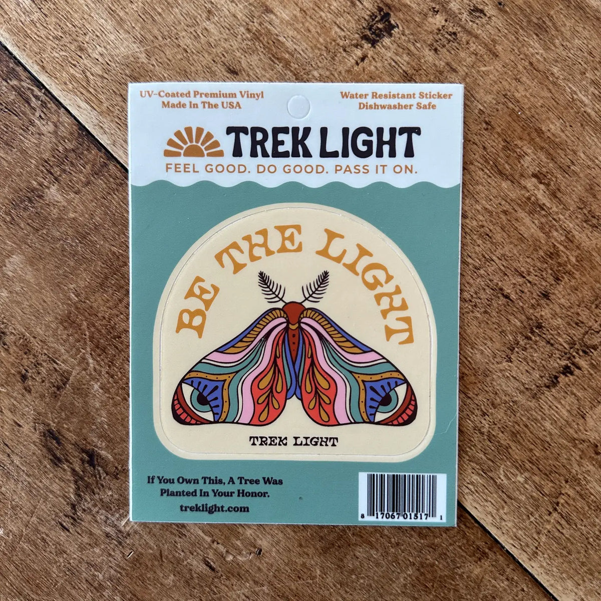 Be The Light circular sticker with a colorful moth design on Trek Light packaging.