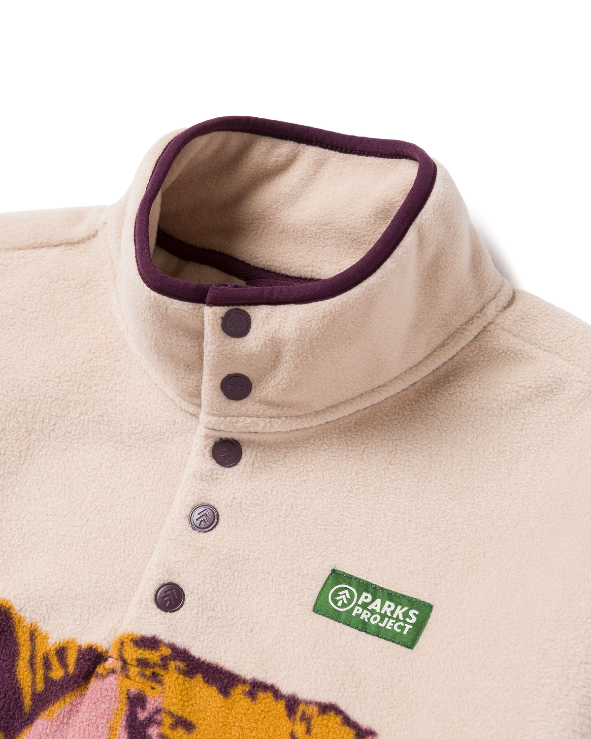 Beige Zion Views Trail Fleece close up of collar with purple trim and logo buttons along the placket