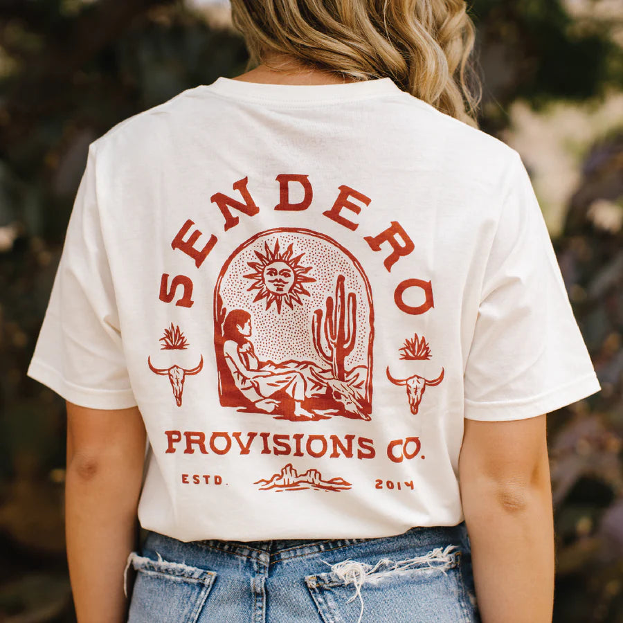 Back view of white De Sonora tee worn by model with a large red desert graphic featuring sun cactus and longhorn motifs