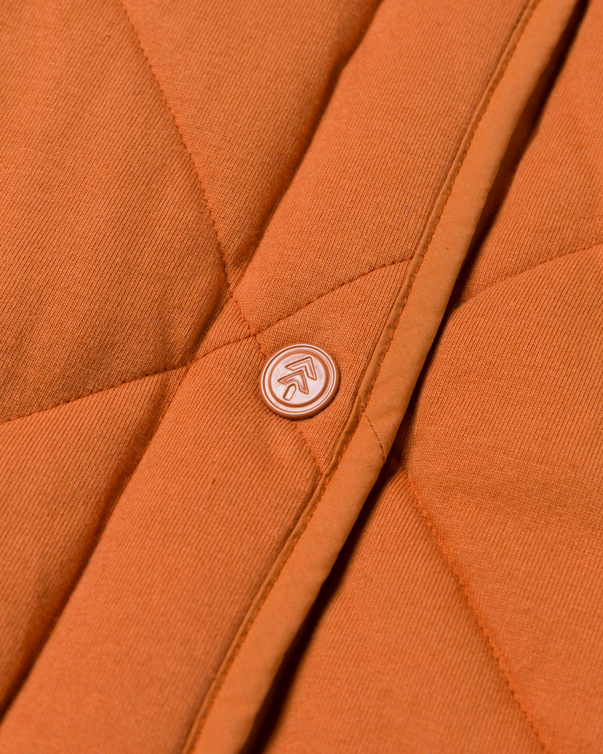 Back view of orange quilted puffer vest with diamond stitching and collar