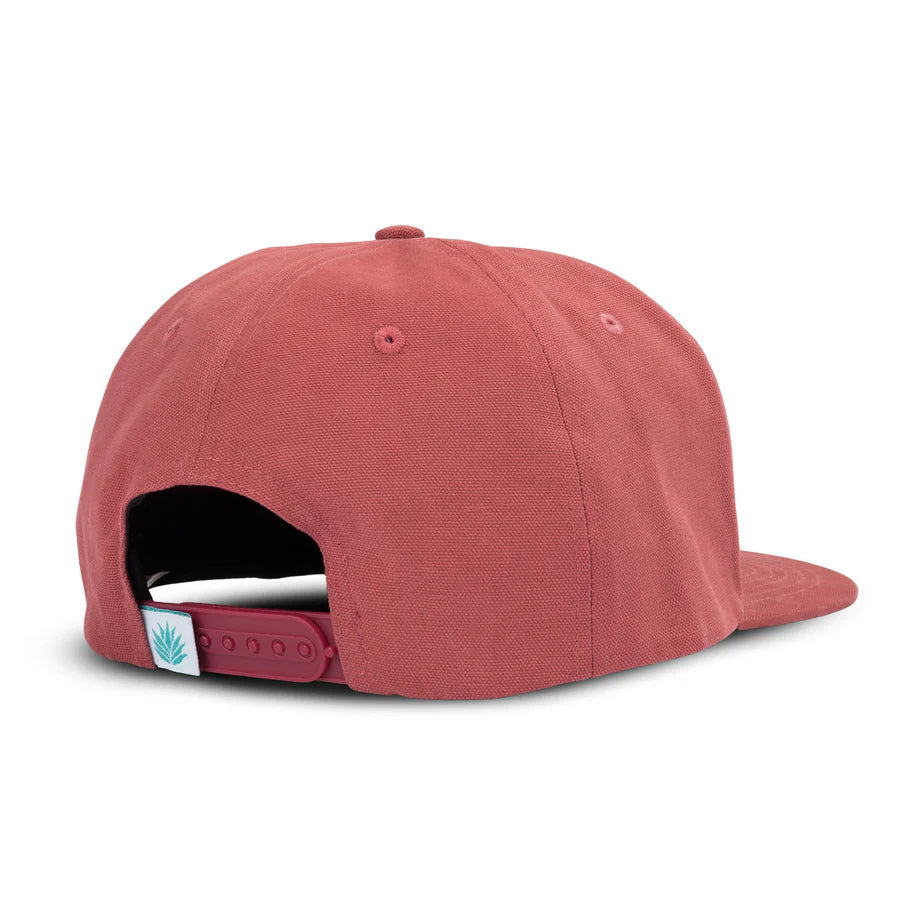 Back view of red So Bueno flat brim hat with adjustable strap and teal leaf tag.