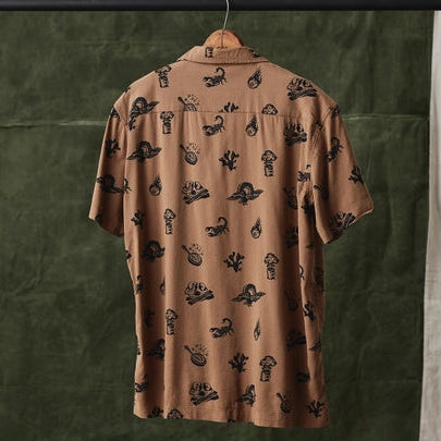 Back view of brown desert print casual button up on a hanger, featuring all over black illustrations