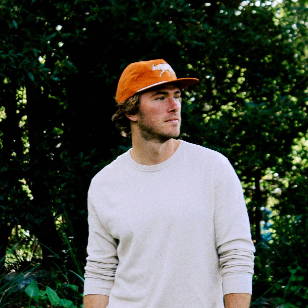 Man wearing The Coyote Hat outdoors, looking to the side in a beige sweater