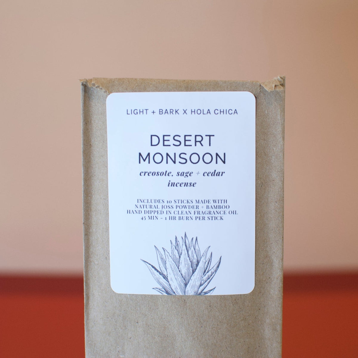 Front of brown cardboard box with a white Desert Monsoon label featuring a cactus illustration