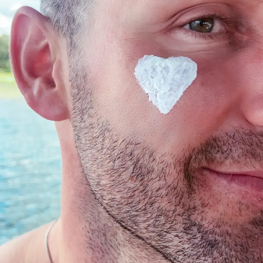 Close-up of a man with a heart shaped dab of sunscreen on his cheek