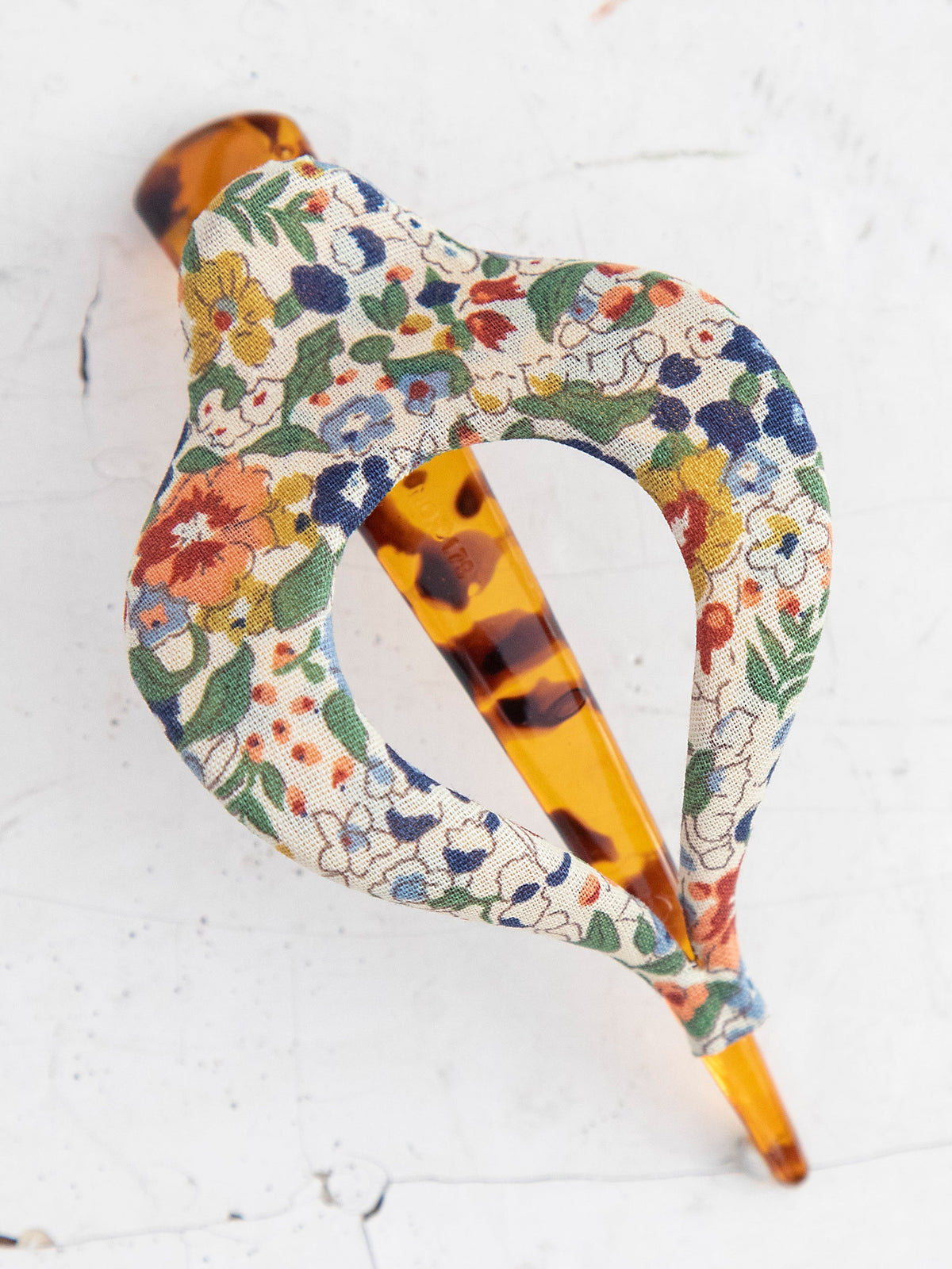 Close up of a boho clip wrapped in floral fabric with a tortoiseshell acetate component