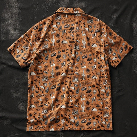 Brown short-sleeve button-up shirt with taco and desert cactus prints laid flat.