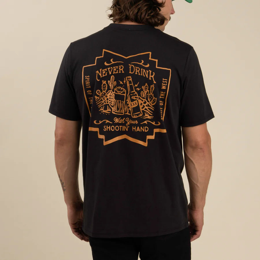 Back view of black Never Drink With Your Shootin Hand Salud Edition T Shirt with a large orange back graphic