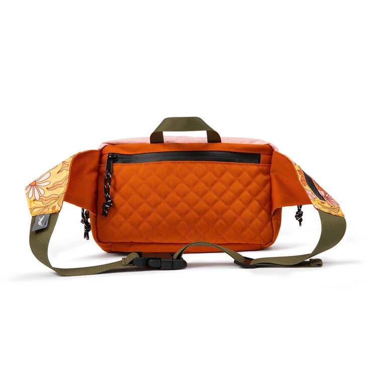 Orange quilted Everyday Fanny Pack Bloom with front zip pocket, top handle, and green adjustable strap.