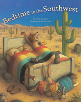 Cover of Bedtime in the Southwest showing a bear in a bed in a desert setting with cacti and a rainbow quilt.