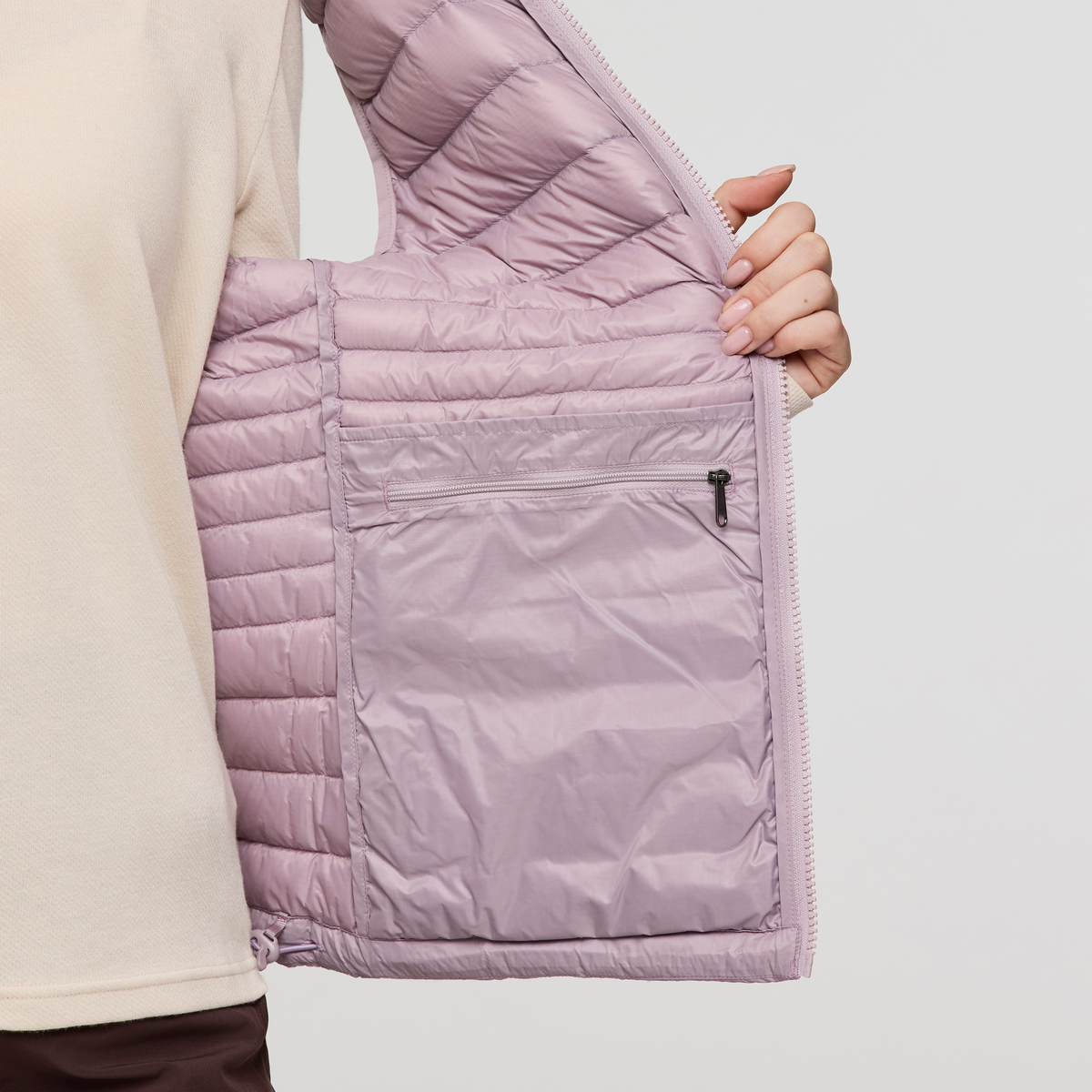 Light pink Cotopaxi Fuego Down Vest interior with quilted lining and zip pocket