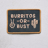 Embroidered patch with BURRITOS OR BUST on dark fabric, flanked by a peace sign and a cactus