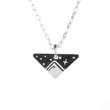 Wanderlust mini necklace with a black triangular mountain pendant and white detailing