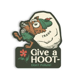 Cartoon owl peeks from a trash bag on a Give a HOOT Don’t Pollute vinyl sticker with a red flower