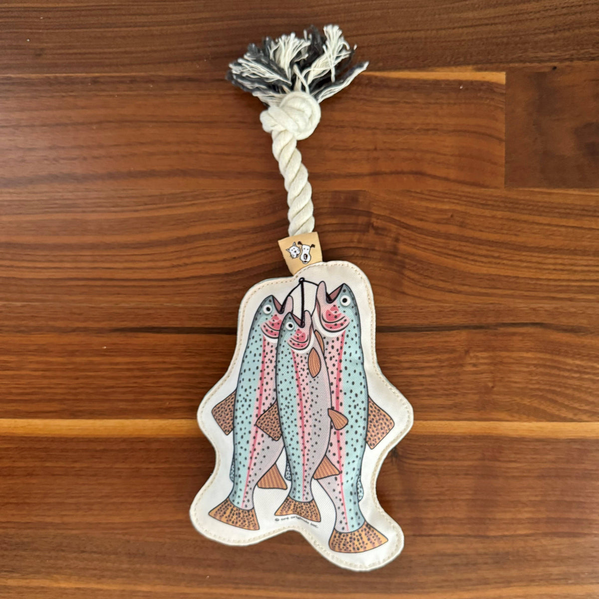 Trout rope dog toy with a knotted cotton rope and a beige tag with dog illustrations