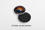 Round I Love Peeing Outside patch with a mountain and sunset design on a white background