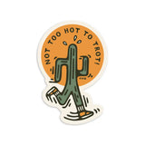Circular sticker with a green cactus character against an orange background and the phrase Not Too Hot To Trot