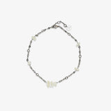 Sea Treasures Anklet close-up with a silver chain and small white shell beads and a round charm