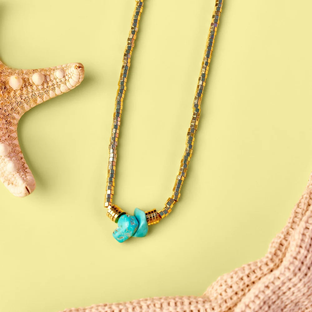Golden touch choker with multicolor gradient beads and turquoise centerpiece on a pale yellow background