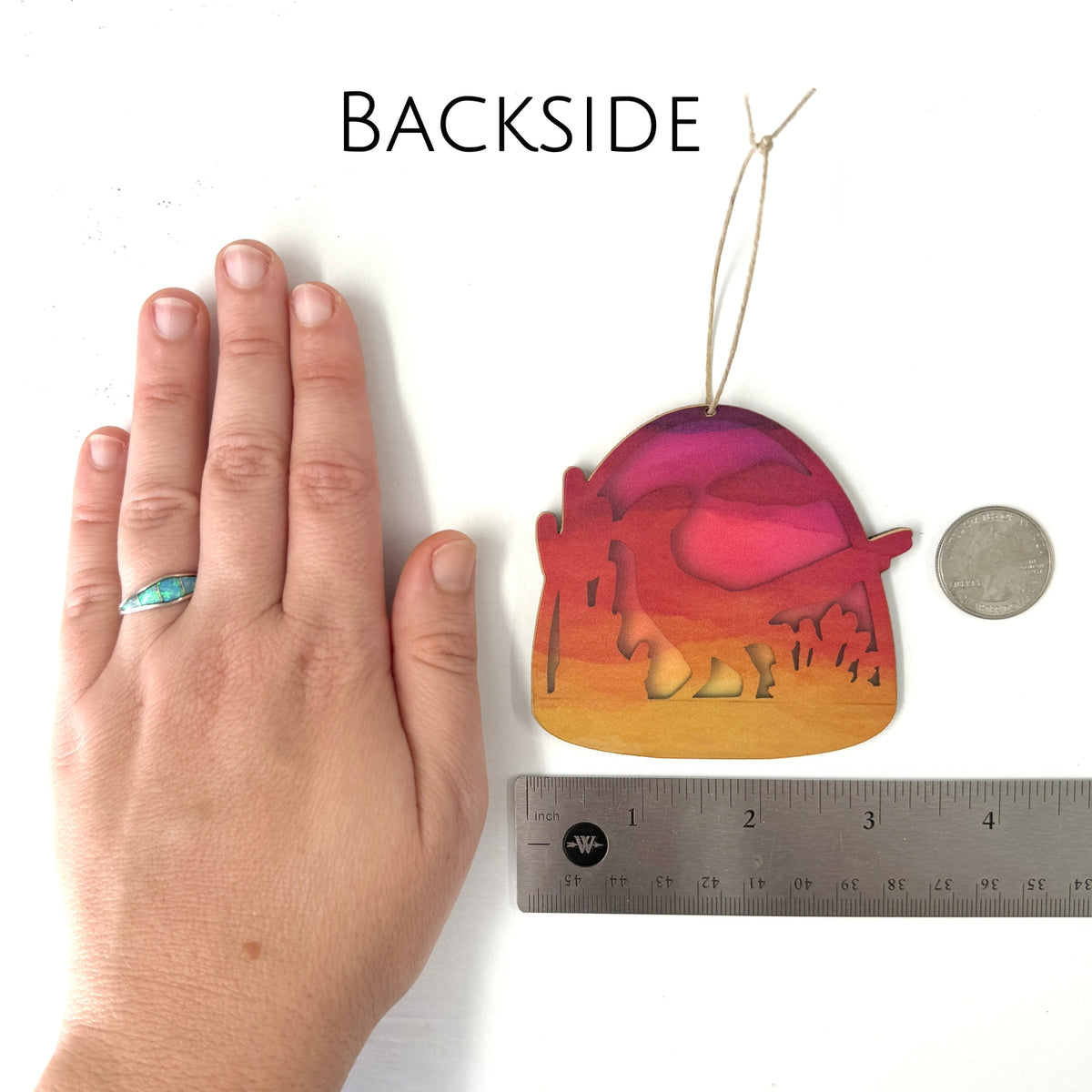 Backside of the desert ornament showing a desert silhouette against orange sunset gradient