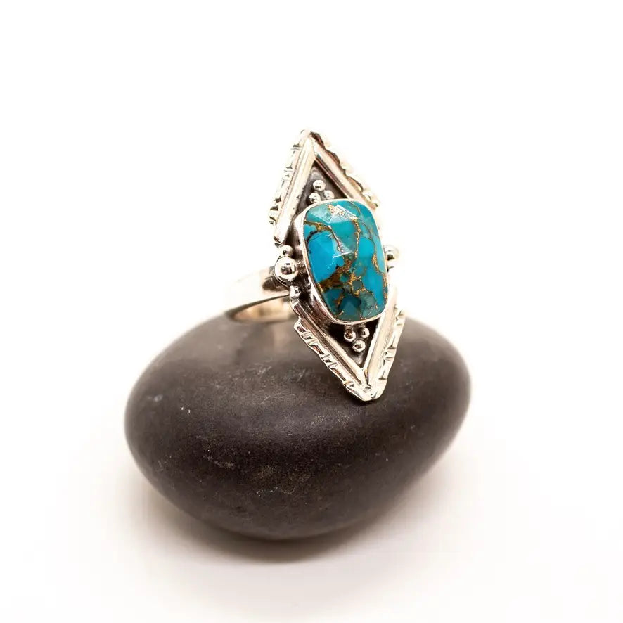 Copper turquoise silver point ring with a blue turquoise cabochon set in a geometric silver frame.