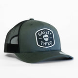 Olive safety trucker hat with black mesh back and a front patch reading Safety Third with a skull emblem.