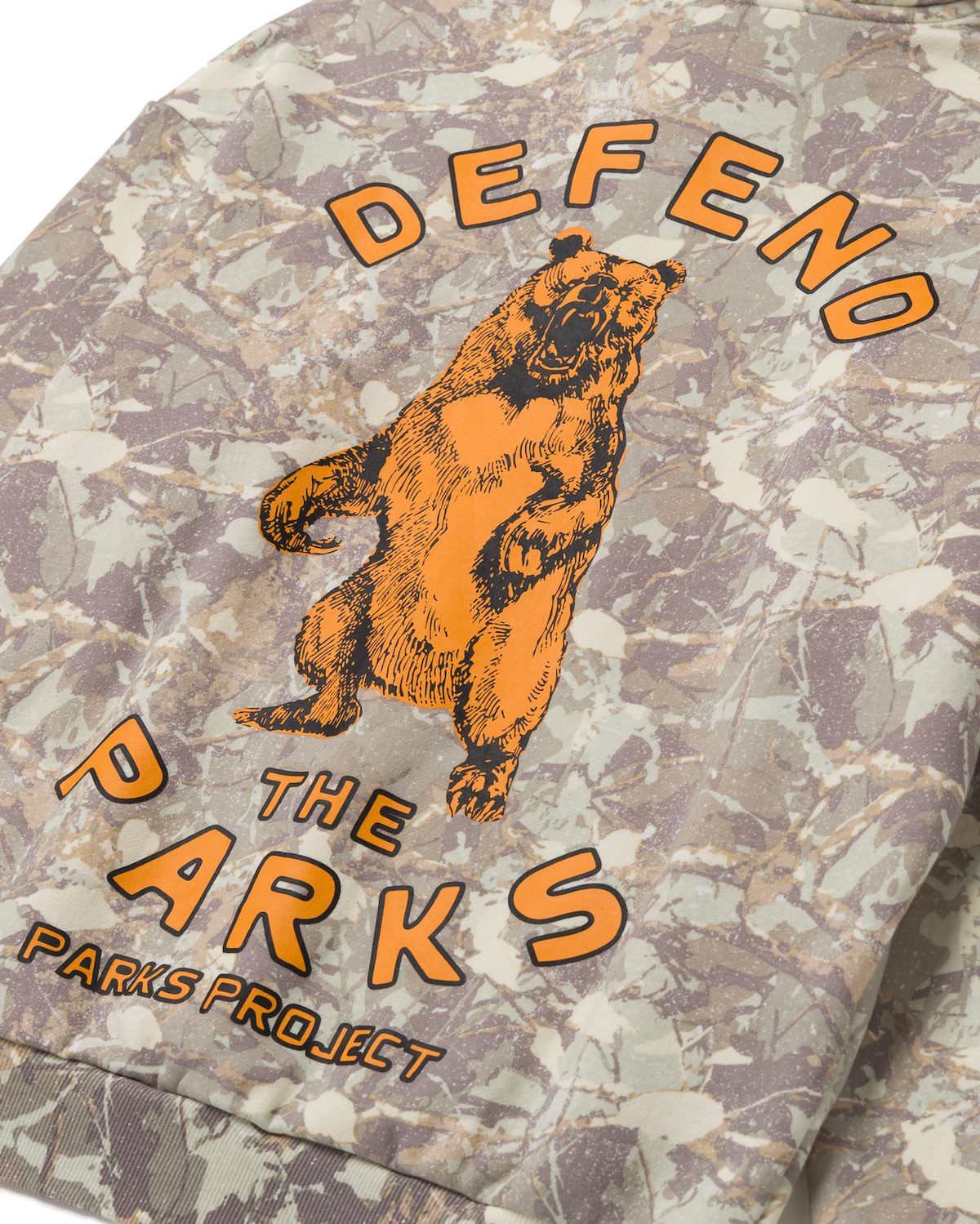 Lower back panel of the camo hoodie with an orange bear and PARKS PROJECT text
