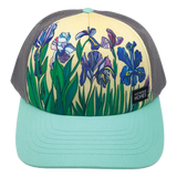 Yellow iris flower print front panel of foam trucker hat with mint brim and gray mesh back.