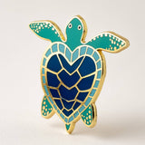 Sea turtle heart enamel pin with gold edges teal head and flippers and a deep blue mosaic shell