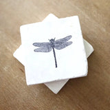 White marble dragonfly coaster with a black dragonfly illustration