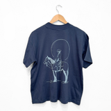 Back view of navy Howdy Unisex Boxy Tee on a hanger featuring a large rider illustration inside a circle
