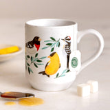 Feathered Friends Birds Mug with vibrant bird illustrations and attached tag.