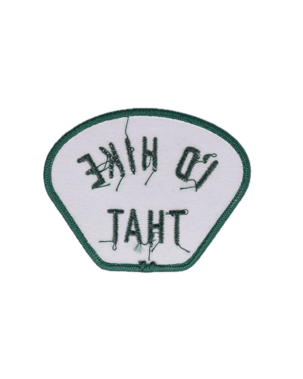 Oval white patch with green border showing stitched lettering and loose threads.