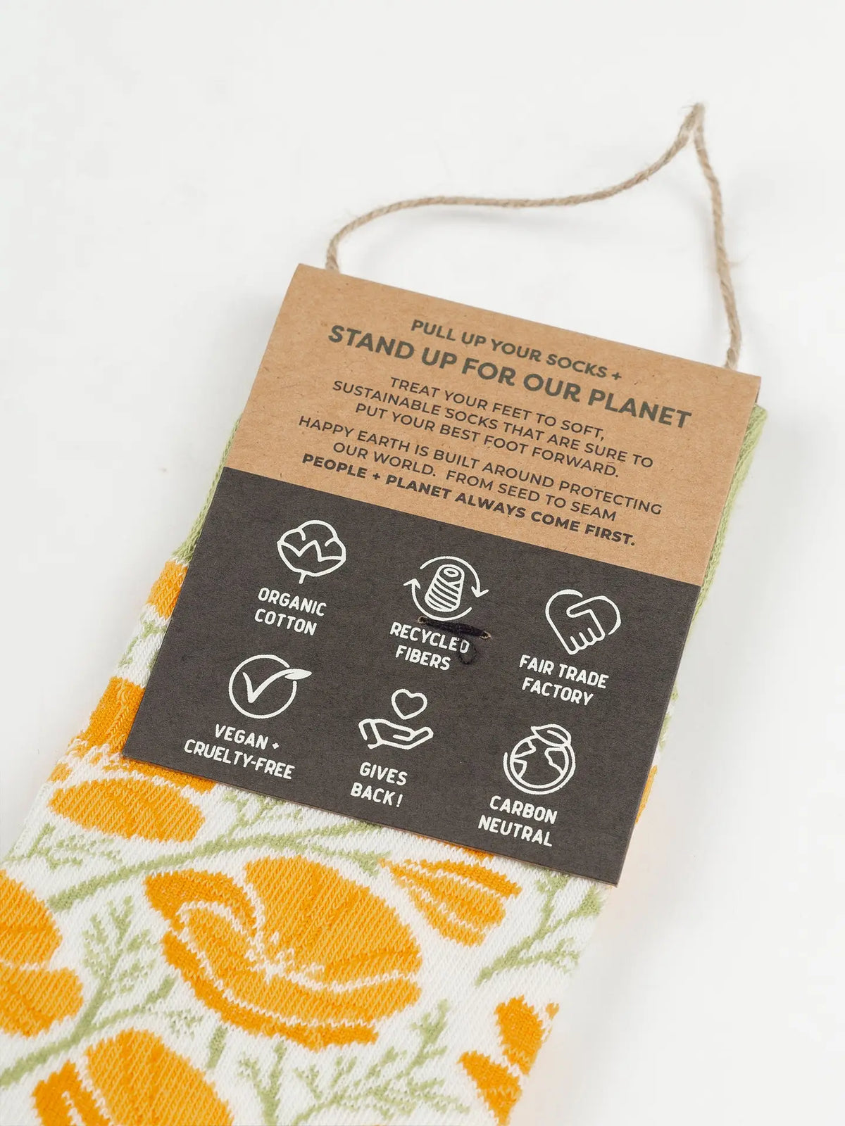 Poppies Socks with orange floral pattern peeking from under a kraft tag