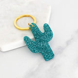 Acrylic cactus shaped keyring with teal glitter and a gold ring