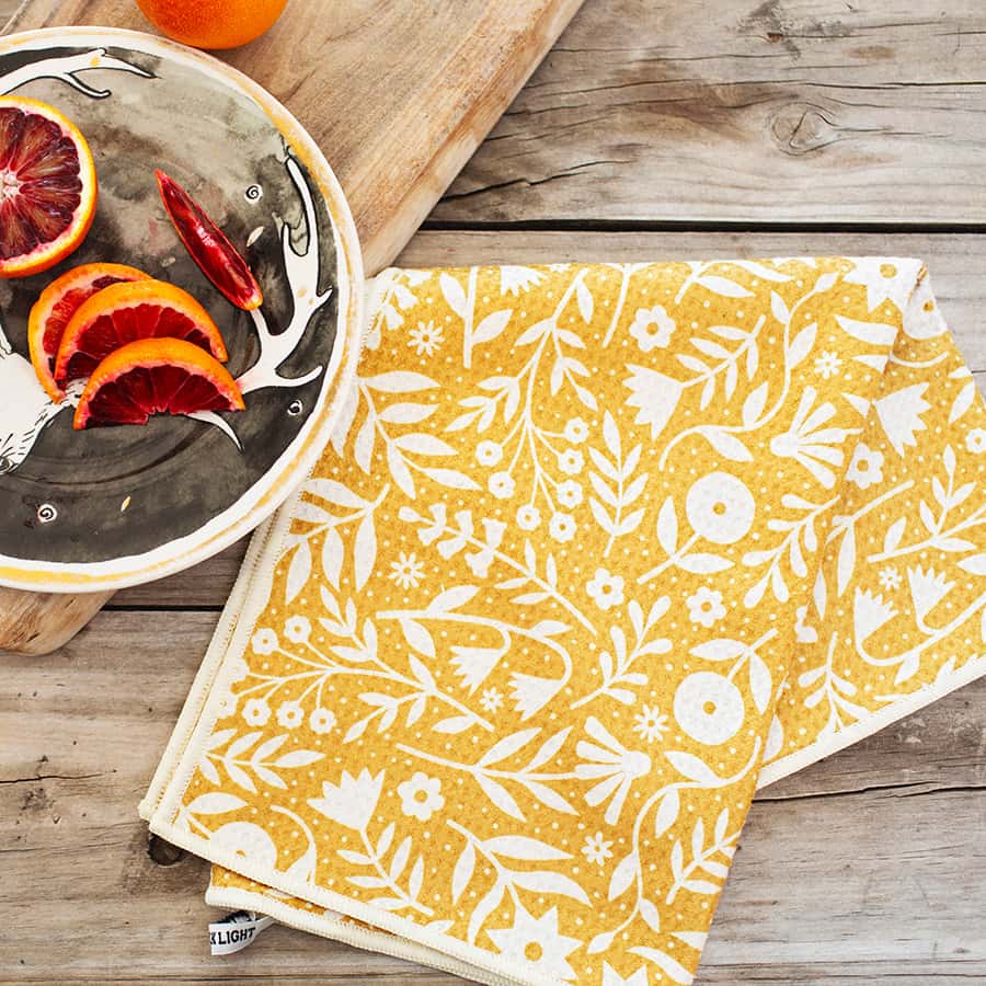 Meadow Flowers kitchen towel in mustard yellow with white botanical motif.