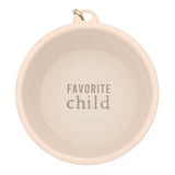 Collapsible pale pink bowl with a gold carabiner and Favorite Child printed inside.