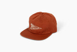 Born Traveler flat brim hat in burnt orange with white embroidered logo on the front.