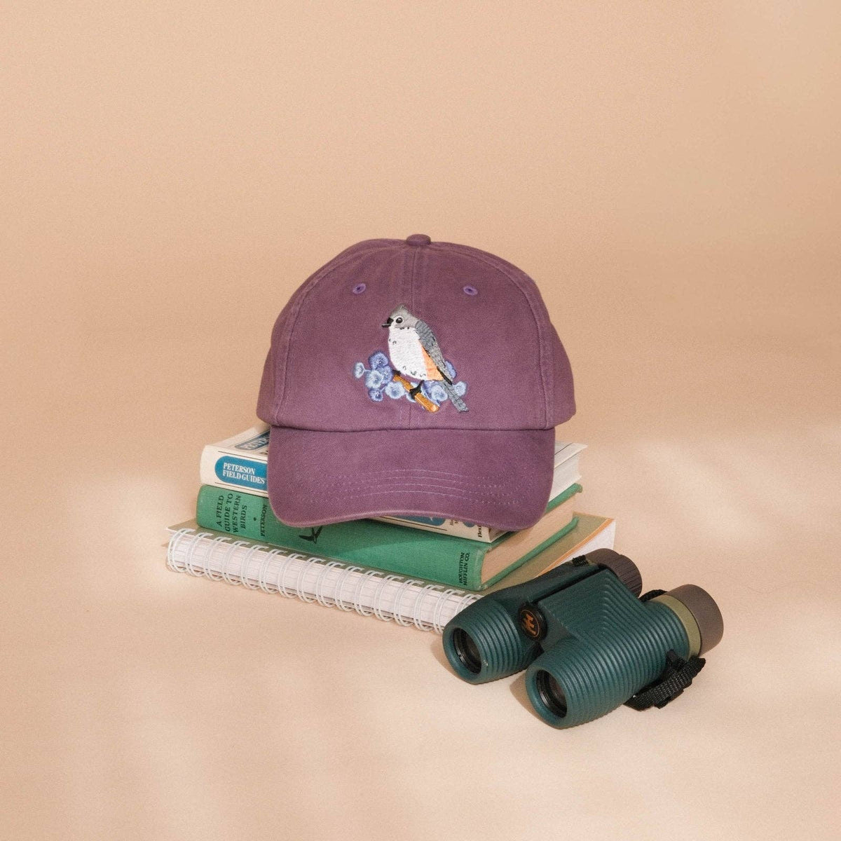 Purple washed dad hat with tufted titmouse embroidery on the front.