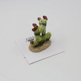 Prickly Pear cactus porcelain miniature with green pads and red fruit on a small base.
