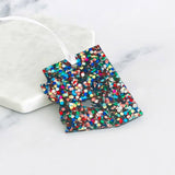 Acrylic Arizona ornament covered in bright multicolor glitter with a white hanging ribbon.