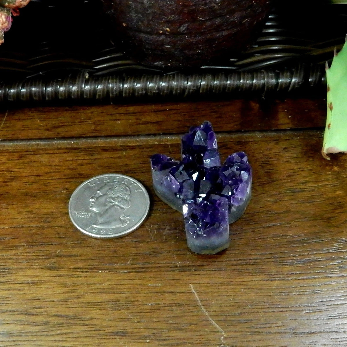 Hand holds purple amethyst cactus crystal pendant with a hole for a necklace