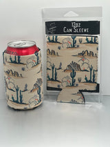 Desert Koozie printed with cacti and desert landscape beside a can and its packaging.